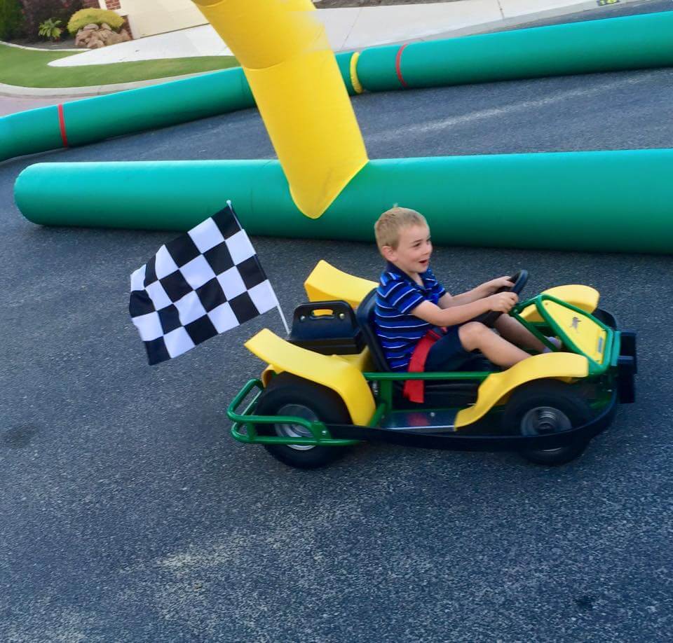 A kid having a blast as he passes by on his go kart at a Perth kids party