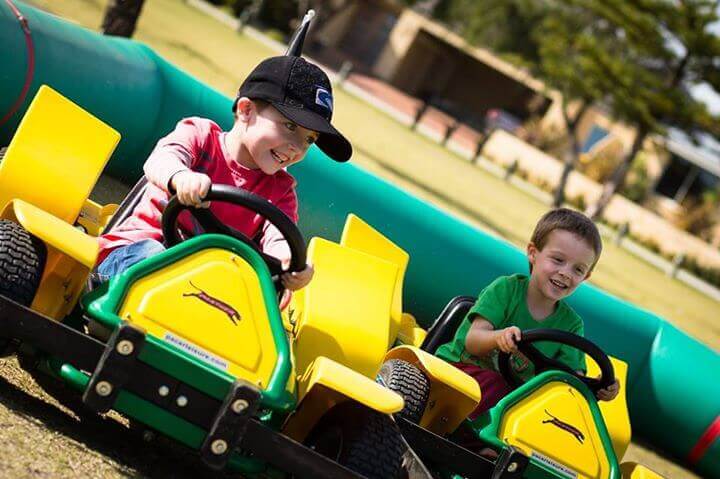 Two kids riding go karts having fun - this was from a Perth kids party